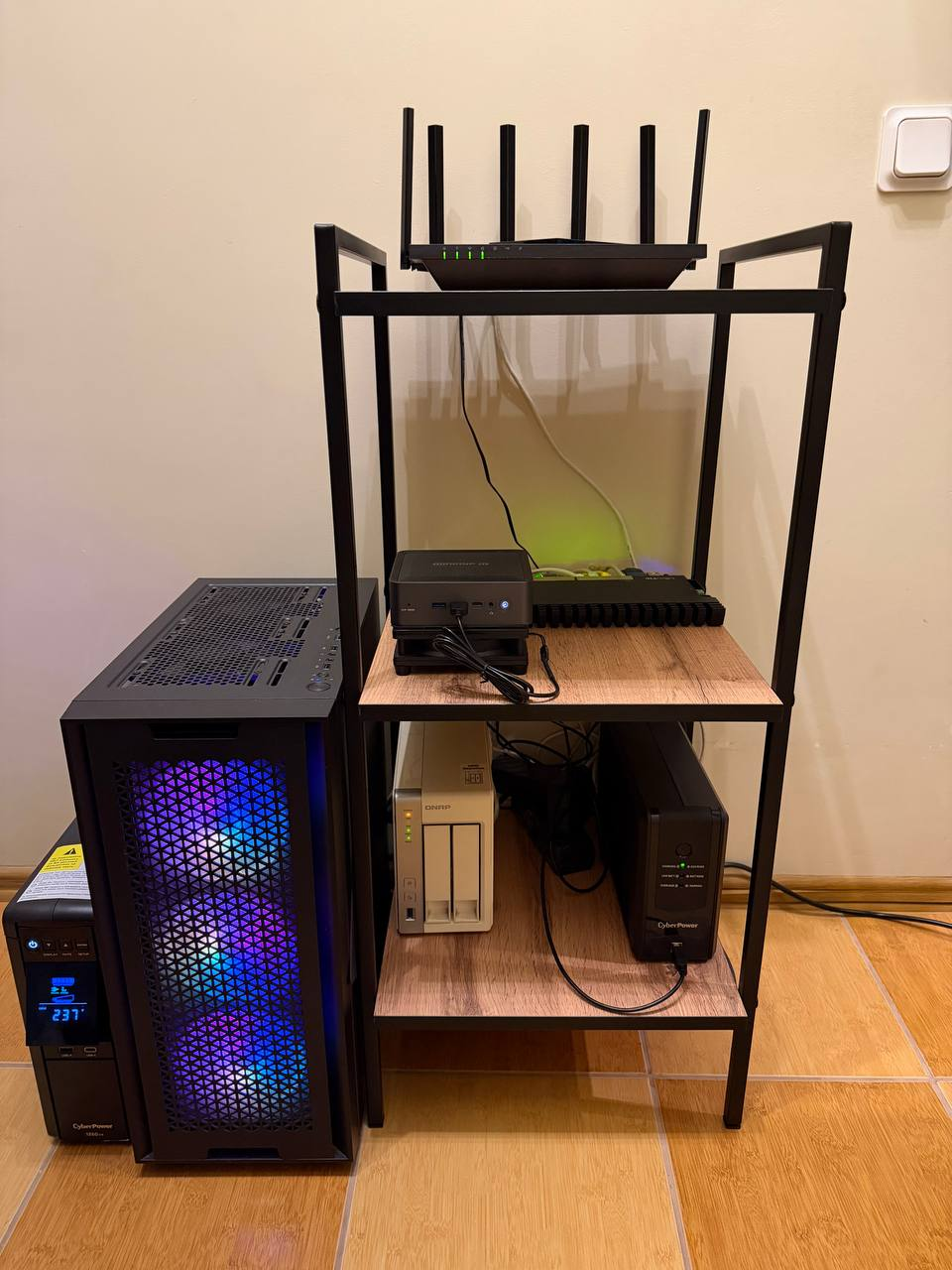 Сверху вниз: Wi-Fi-роутер, мини-ПК — нода A (платформа, 4 ТБ NVMe), MikroTik, NAS с бэкапами и данными Gitea (да, тот самый из грабли №6), ИБП. Слева — нода B: башня с RTX 3090. Второй ИБП — её.